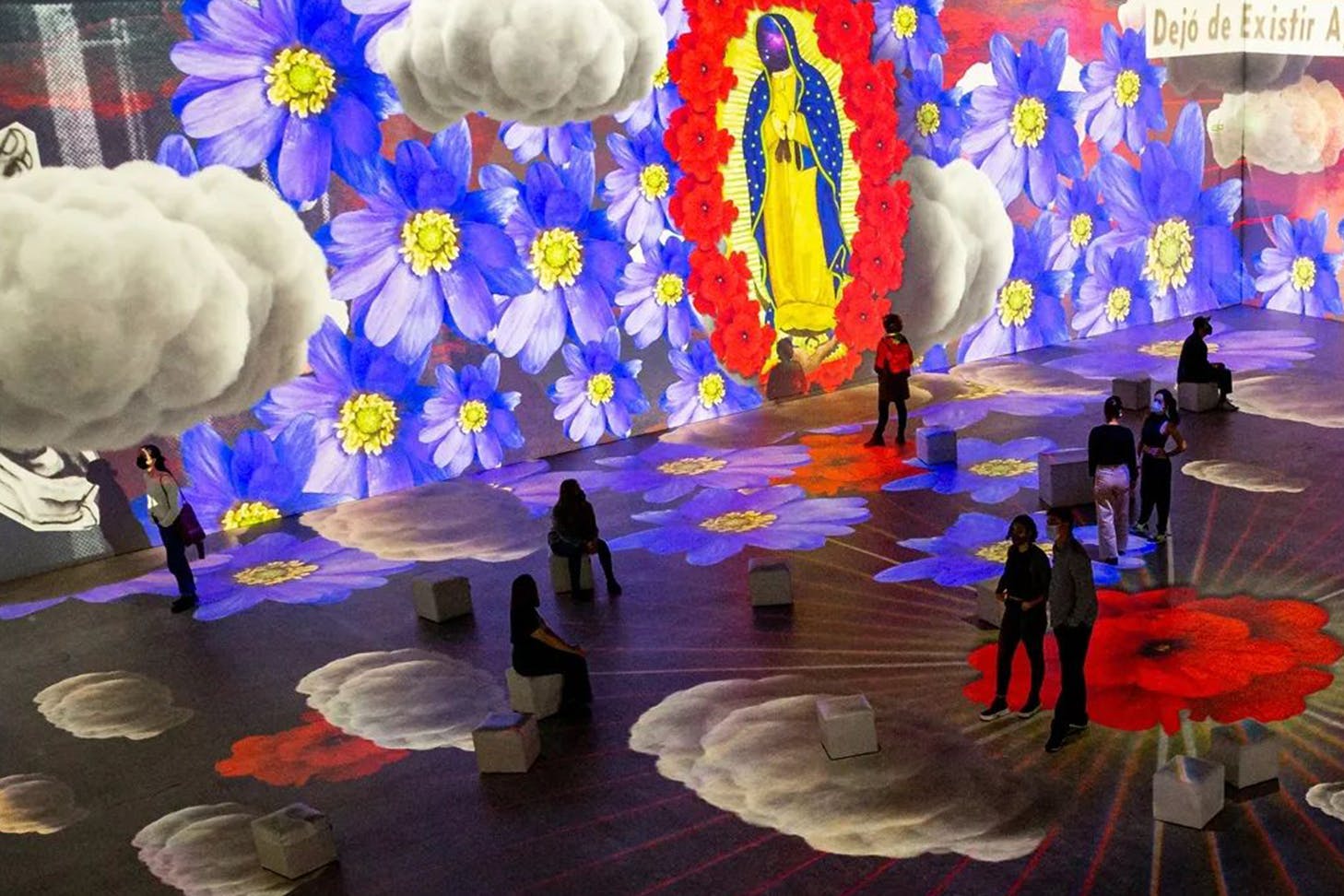 People walking in a vibrant Frida Kahlo art exhibition in Sydney.